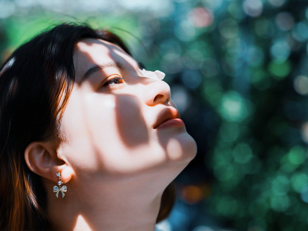 Young woman with warm sunlight on her face, feeling safe and settled as the nervous system rewires toward safety