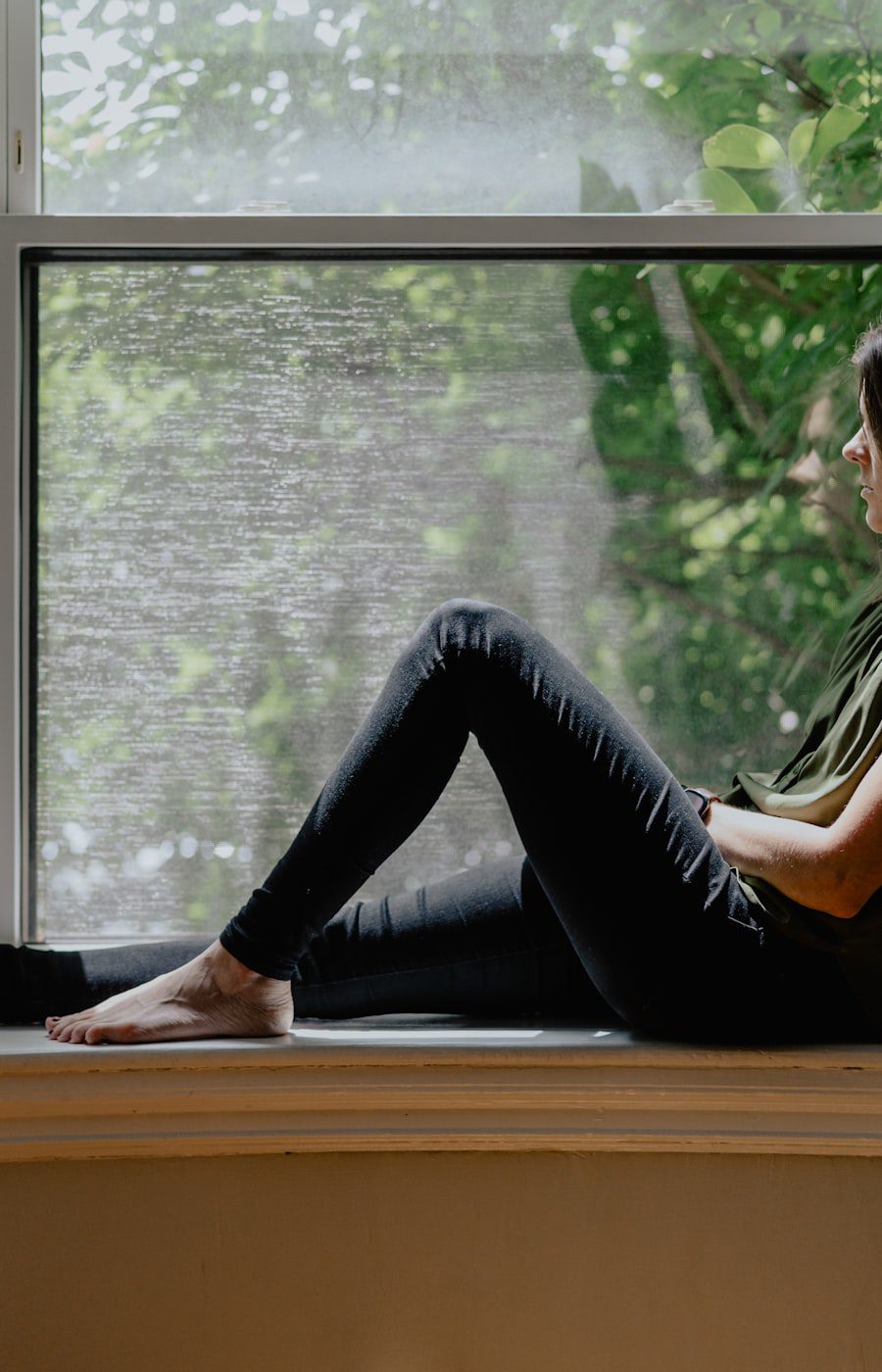 Asian woman sitting by a window, AEDP therapy for Chinese and Asian American adults