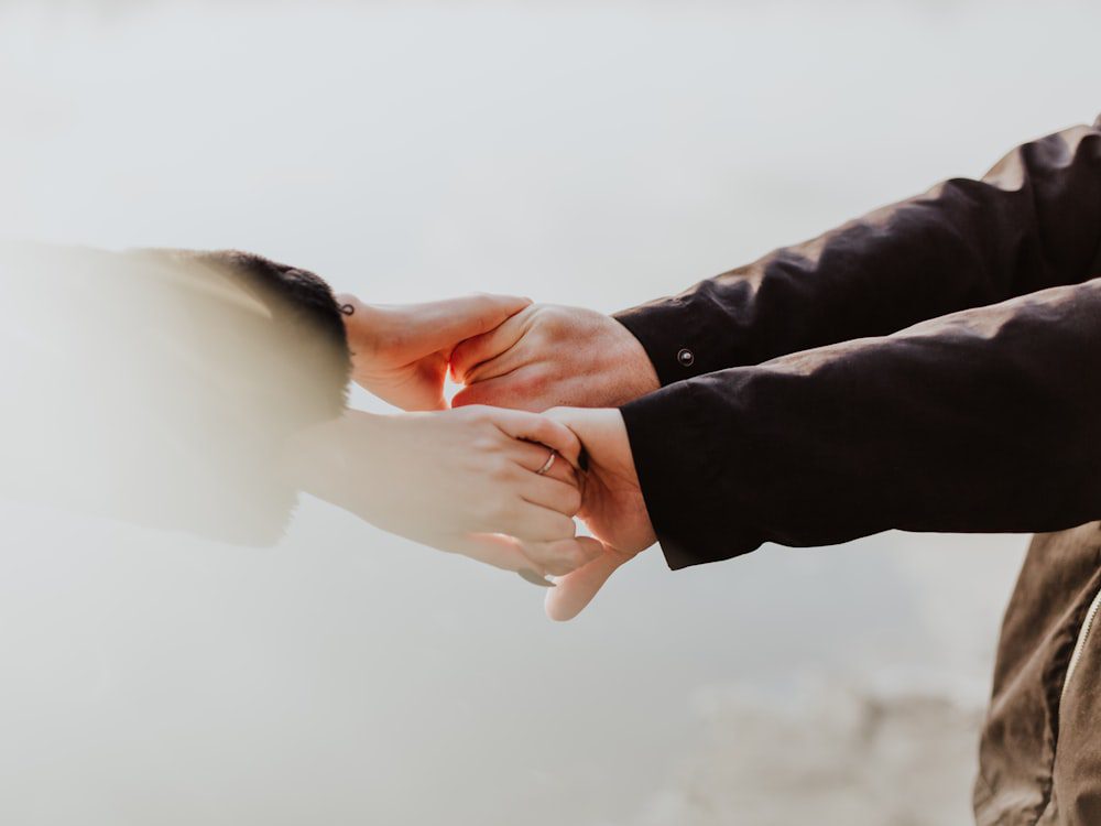 Close-up of a couple holding hands, warm and reassuring bilingual couples therapy support