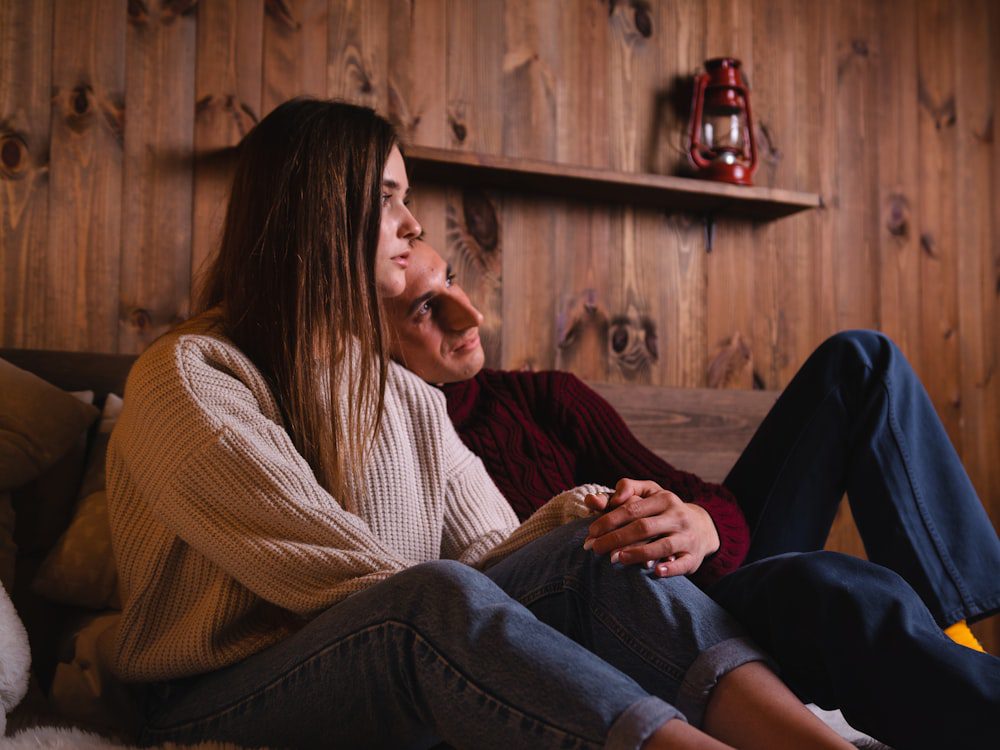 Couple sitting close together on a couch in warm light, slowing down to reconnect during couples therapy