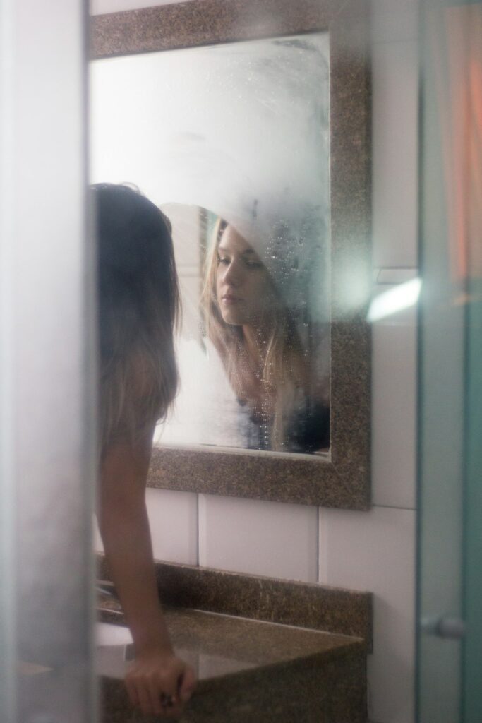 Woman gazing at her reflection in a soft mirror, self-understanding in psychodynamic therapy