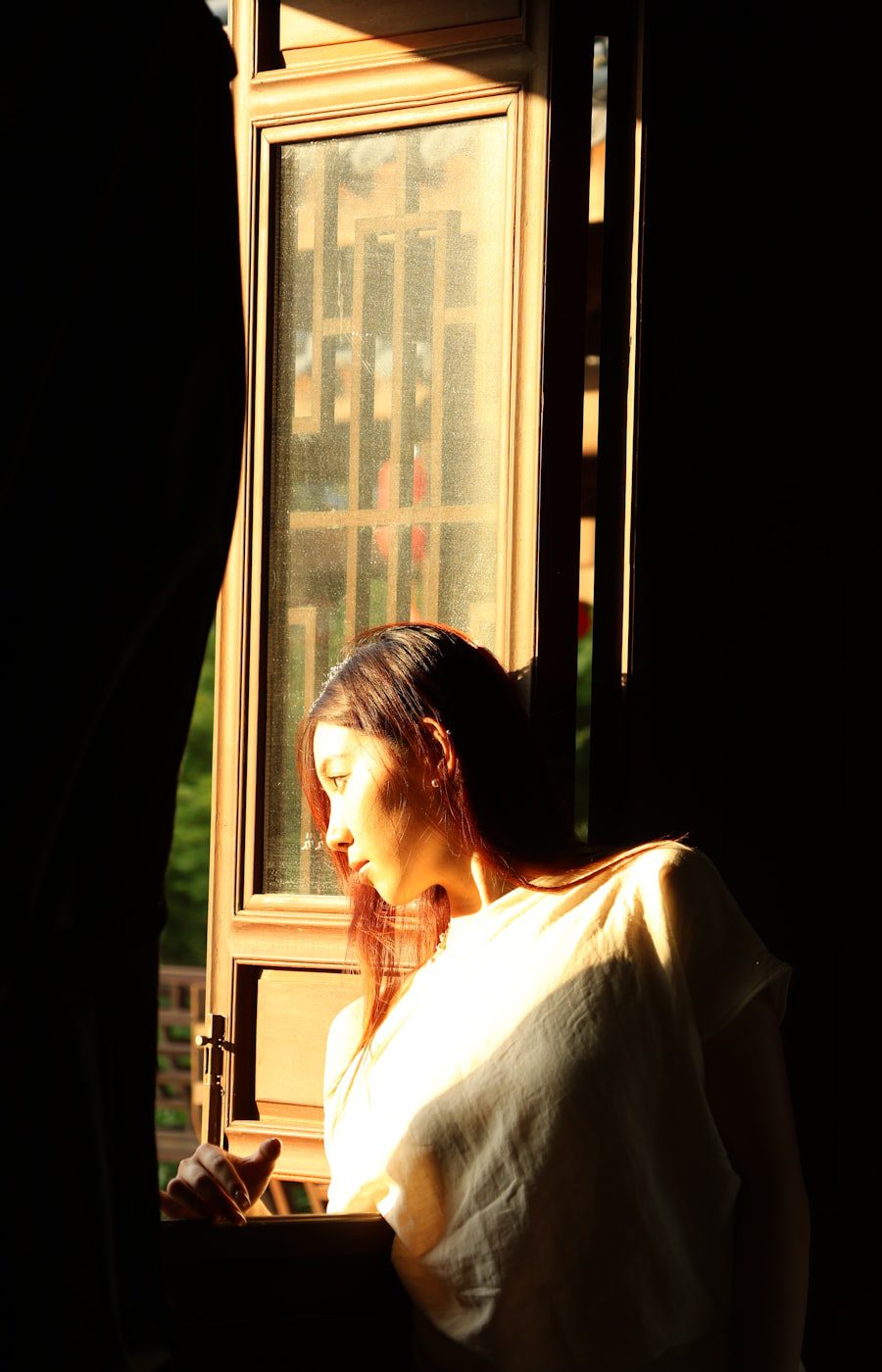 Person sitting quietly in soft light, reflecting on trauma in therapy