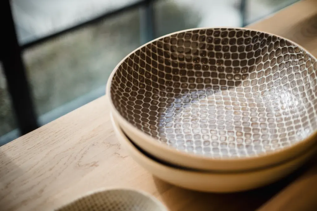 A handmade ceramic bowl in warm window light
