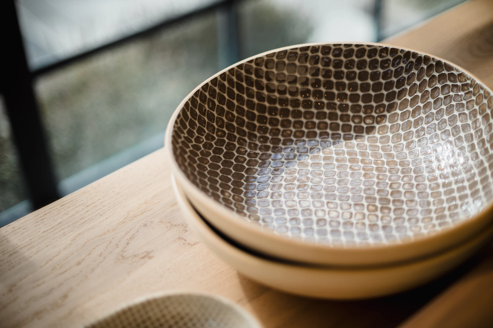 A handmade ceramic bowl in warm window light