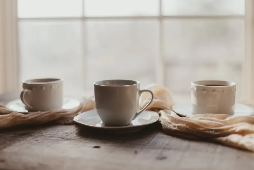 Tea cups on a table by a bright window