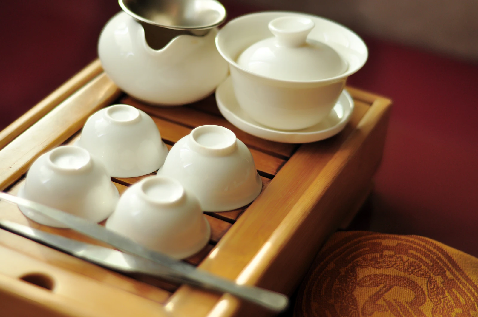 A white porcelain gaiwan tea set on a bamboo tray