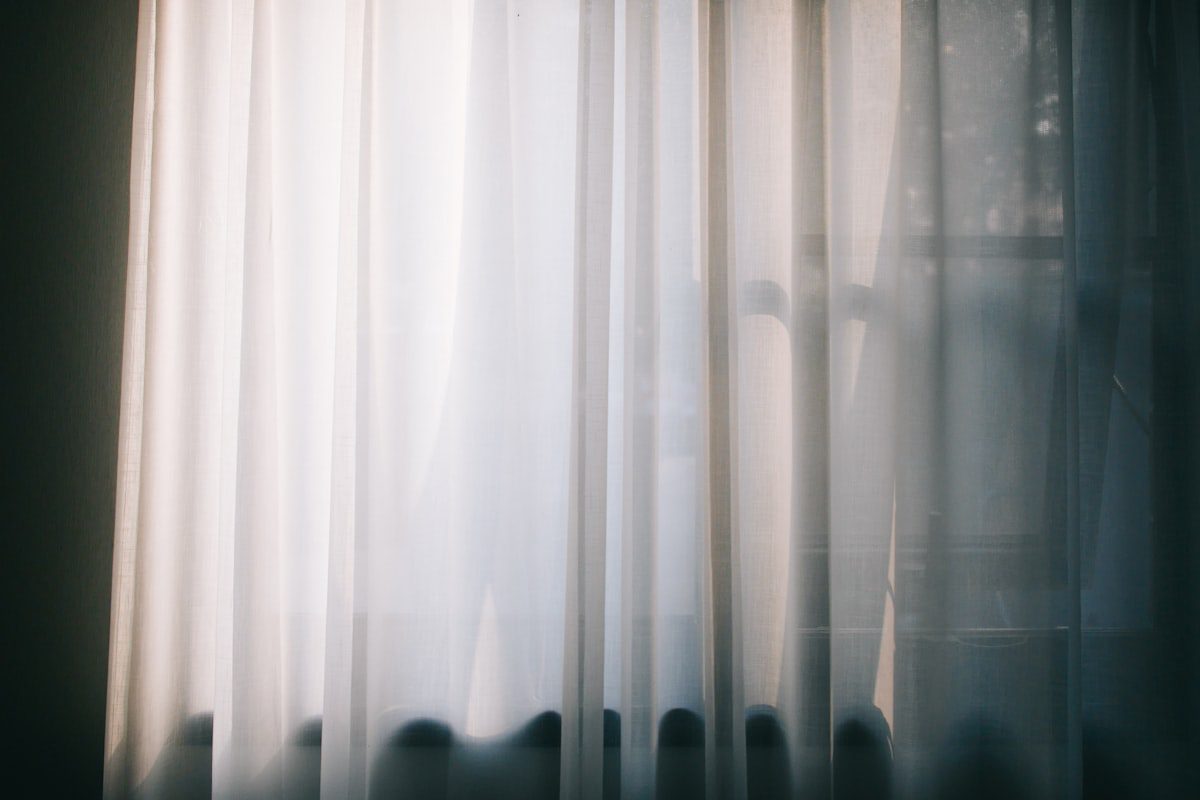 Soft light through a sheer curtain in a quiet room