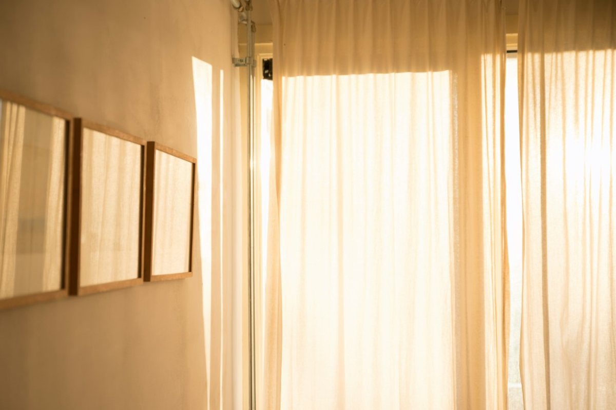 Warm sunlight coming through sheer curtains in a quiet room